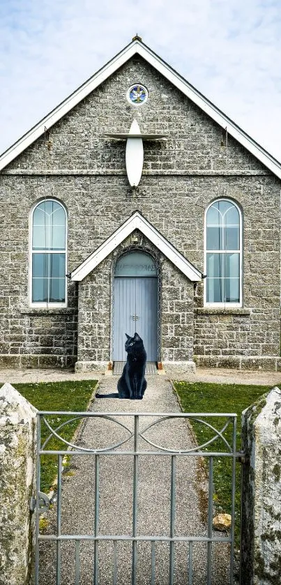 Charming stone church with cat statue and gray brick facade.