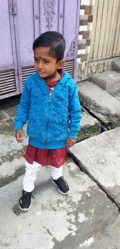 Young boy in blue jacket on urban street.