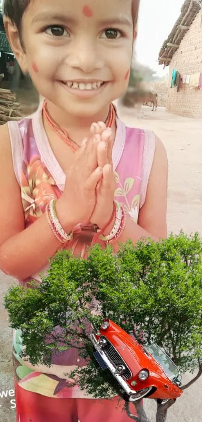 Village child smiling with red car and tree background.