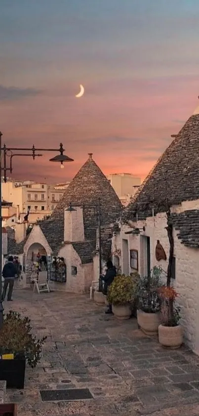 Charming stone village under a dusky sunset sky with crescent moon.