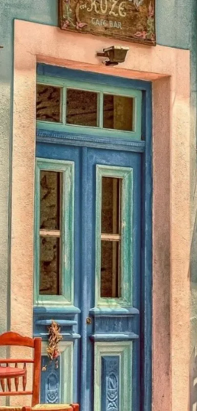 Charming vintage blue door with red chairs in a rustic café setting.