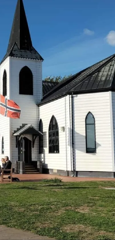 White church with blue sky and pathway in a serene setting.