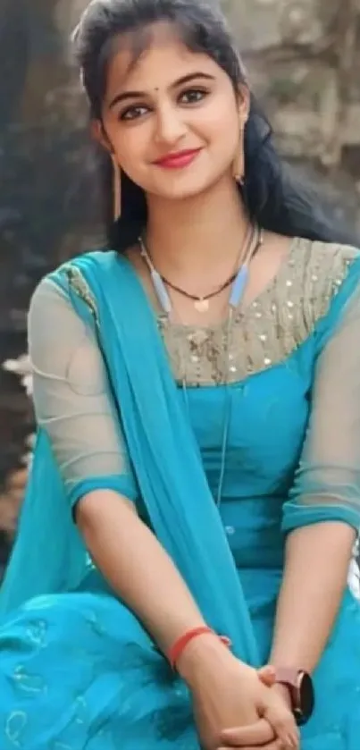 Woman in a vibrant blue dress sitting outdoors.