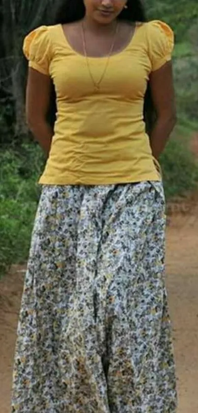 Yellow top and floral skirt on serene path.