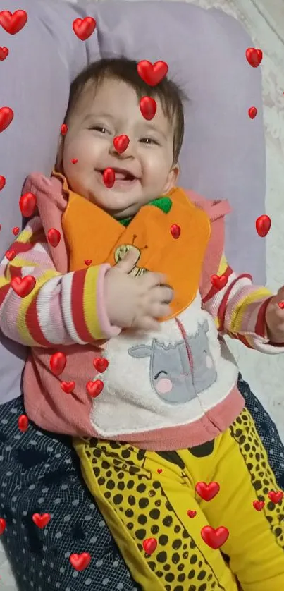 Smiling baby with heart overlay on wallpaper