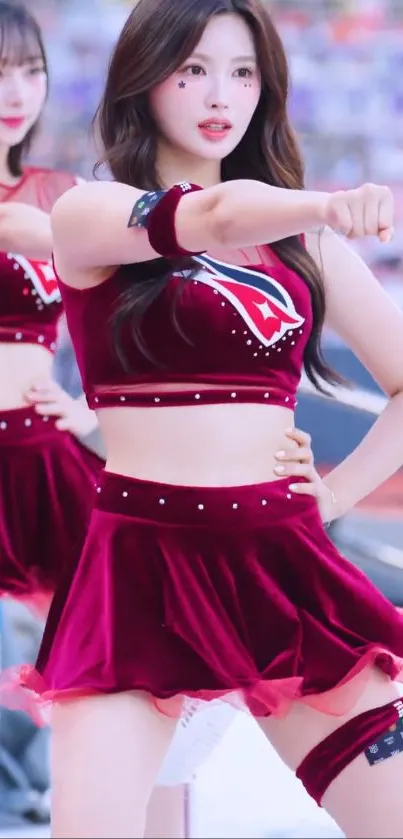 Two dancers in maroon performing energetically.
