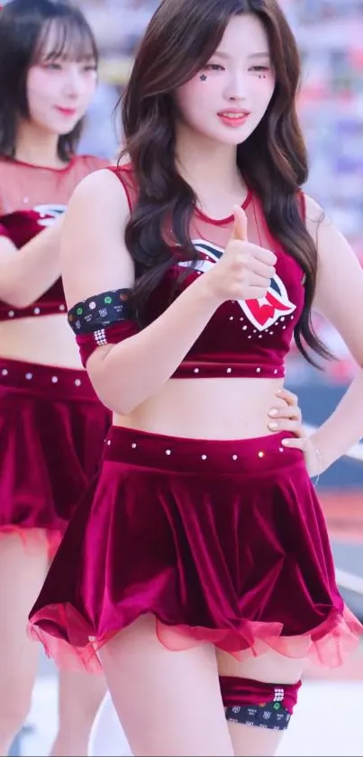 Cheerleaders performing energetically in red attire at a sports event.