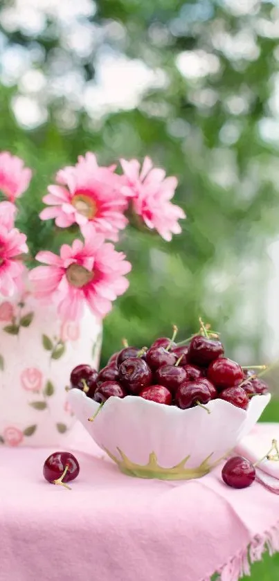 Bowl of cherries and pink flowers on a table.
