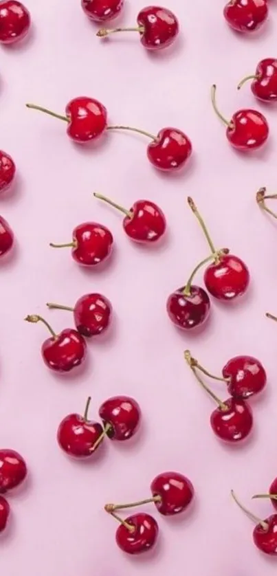 Red cherries arranged on a soft pink background, creating a vibrant pattern.