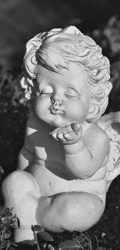 Monochrome cherub statue blowing a kiss outdoors.