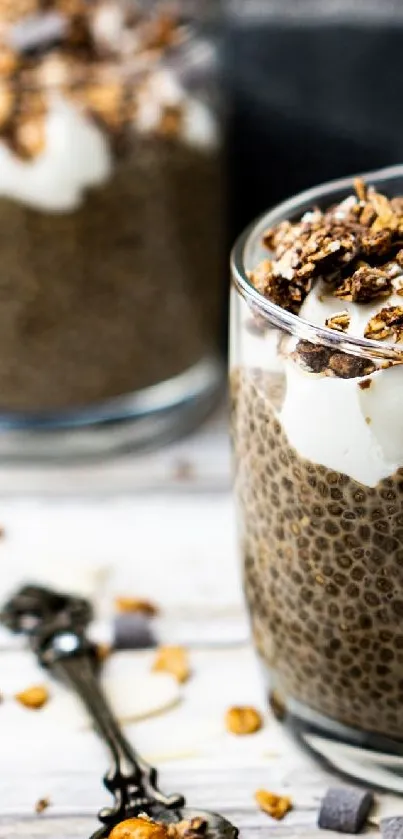 Chia pudding with granola in glass cup on wooden table.