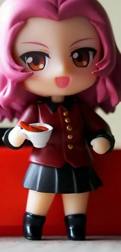 Chibi figurine with pink hair holds a small cup, smiling brightly.