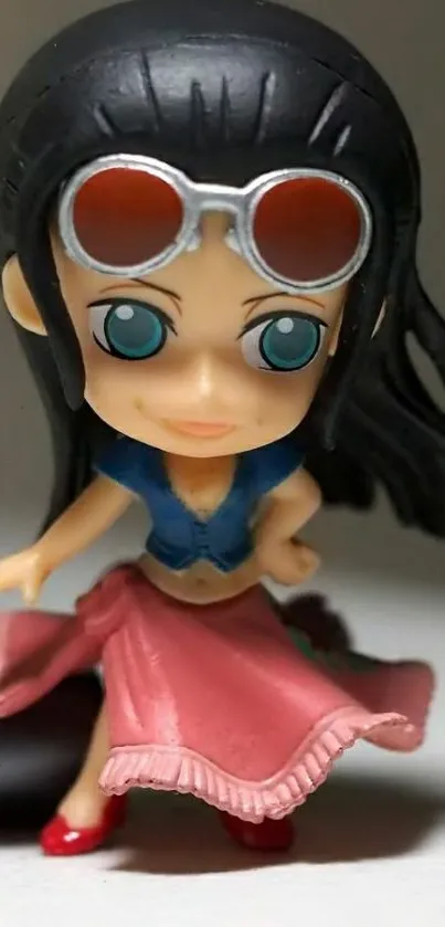 Chibi figurine with sunglasses in pink skirt.