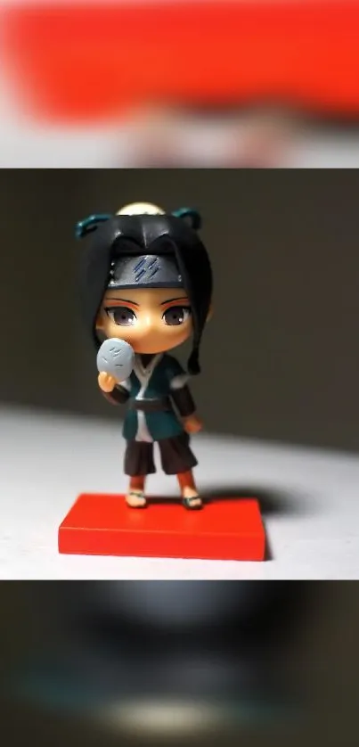 Chibi ninja figure on red stand, anime theme.