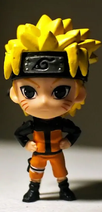 Chibi ninja figurine with yellow hair on a mobile wallpaper.