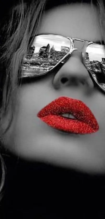 Black and white portrait with red lips and mirrored sunglasses reflecting a city.