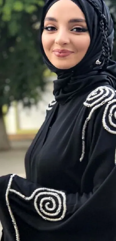 Woman in chic black hijab with elegant swirled embroidery.