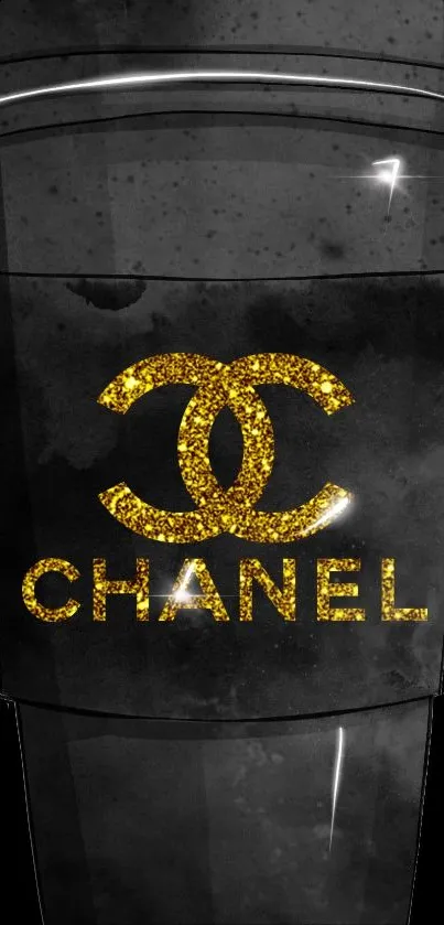 Black coffee cup with gold Chanel logo on dark background.