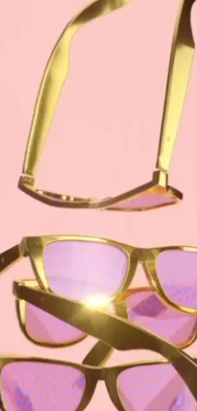 Golden sunglasses on a soft pink background.