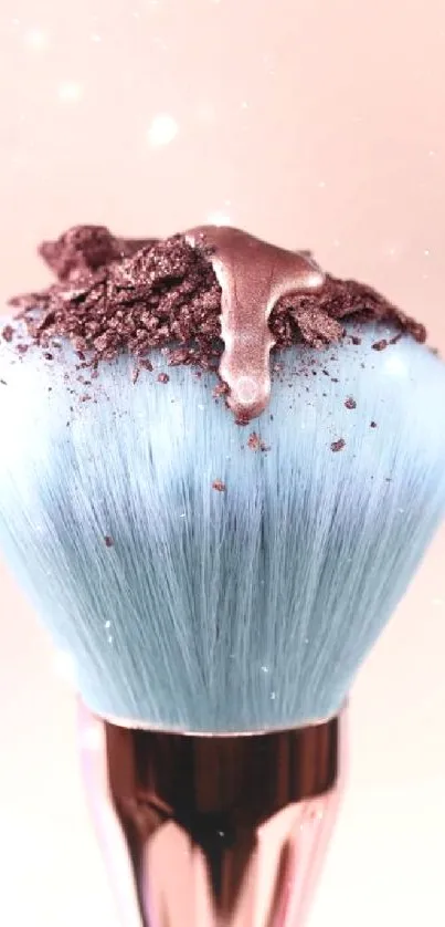 A pastel blue makeup brush with shimmering powder accents.