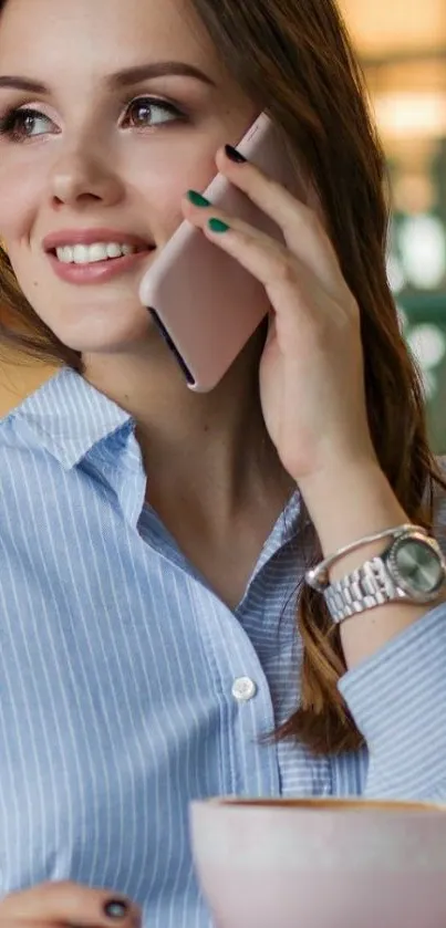 Stylish woman holding phone with coffee, light blue shirt.