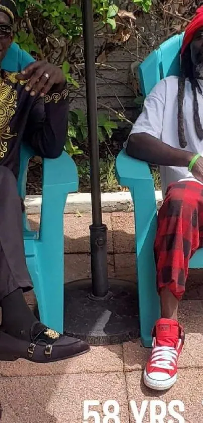 Two people relaxing on turquoise chairs in a garden setting.