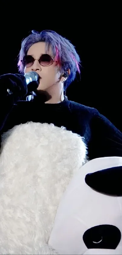 Person wearing panda costume with microphone on stage.