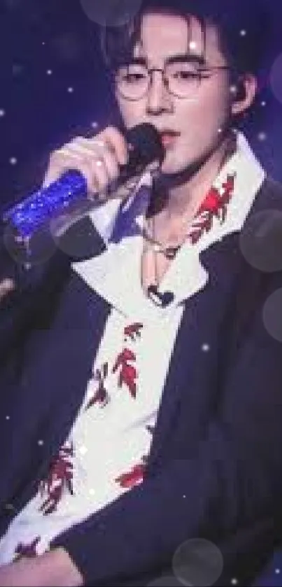 Stylish singer with microphone in a dark suit and floral shirt.