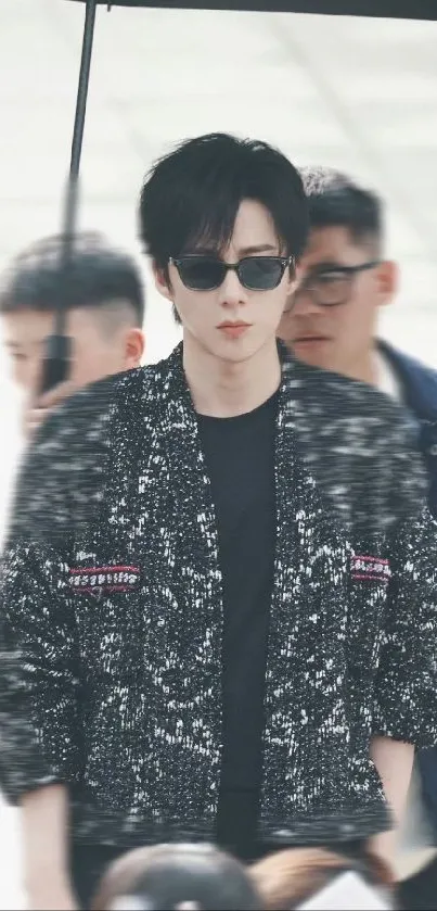 A stylish person in sunglasses and a textured jacket for mobile wallpaper.