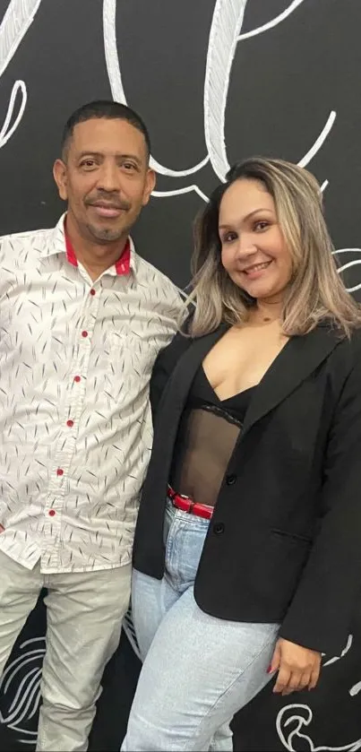 Stylish duo posing against a black background.