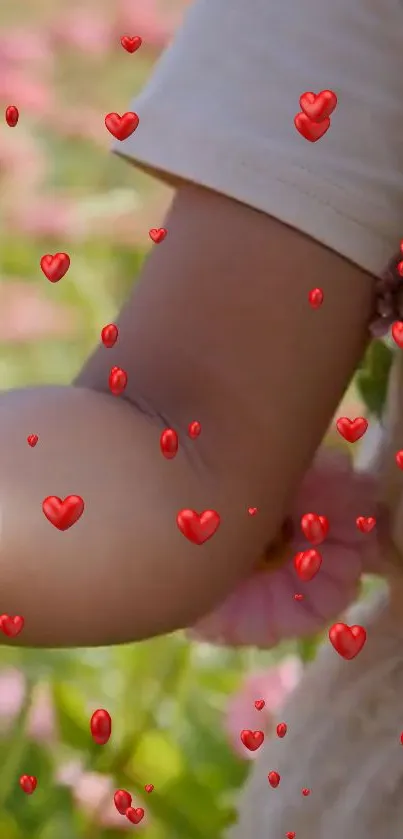 Child's arm with floating red hearts, nature background.