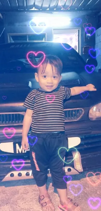 Child standing by a car in a garage under dim light.