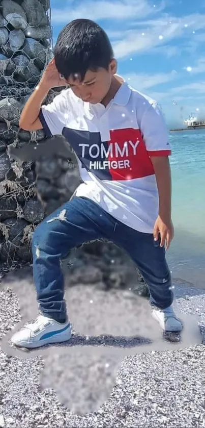 Young child posing by the ocean with a stylish outfit on a sunny day.