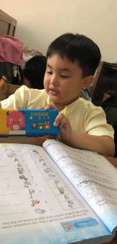 Child drawing at a desk with colorful stationery.