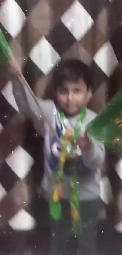 Child cheerfully waving green flags in front of a checkered background.