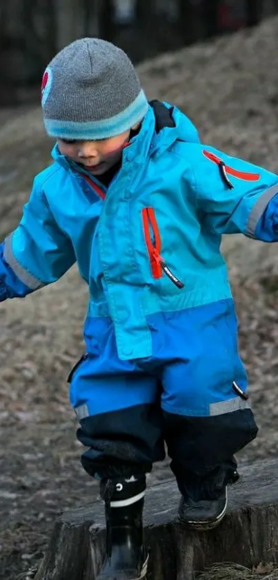 Child in blue winter outfit playing outdoors.