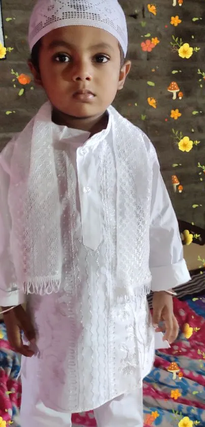 Child in traditional white attire with floral background.