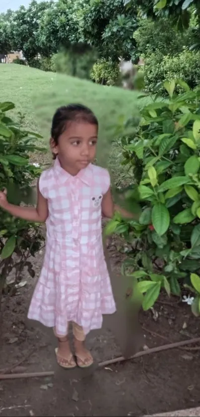 Young girl standing in green garden.