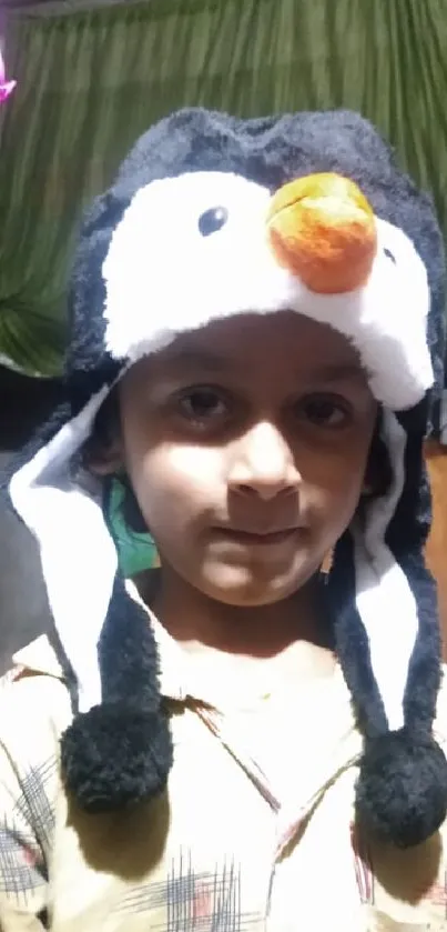 Child wearing a penguin hat in a playful scene.