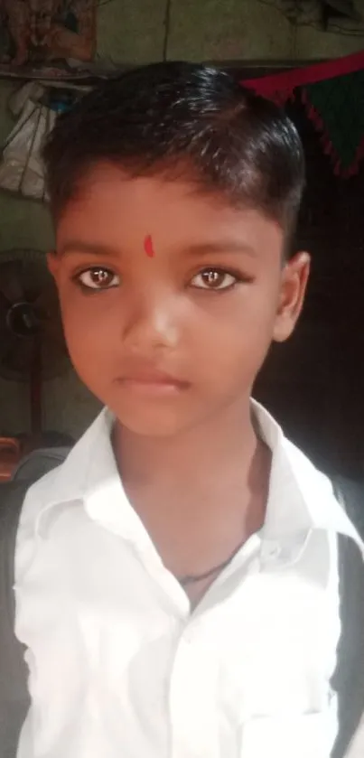 Young boy in a school uniform with earthy background tones.