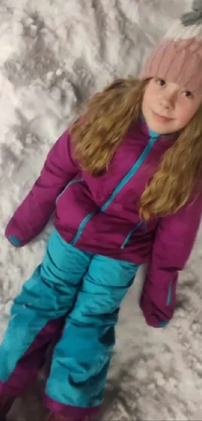Young girl in winter clothes on snowy ground