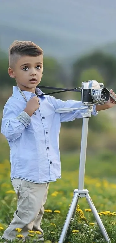 Young boy with camera in green field.