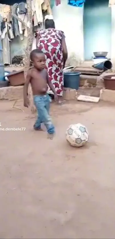 Child plays soccer in a rustic yard.