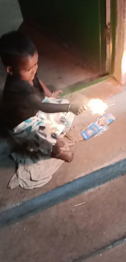 Child plays with sparklers on a stone step at night.