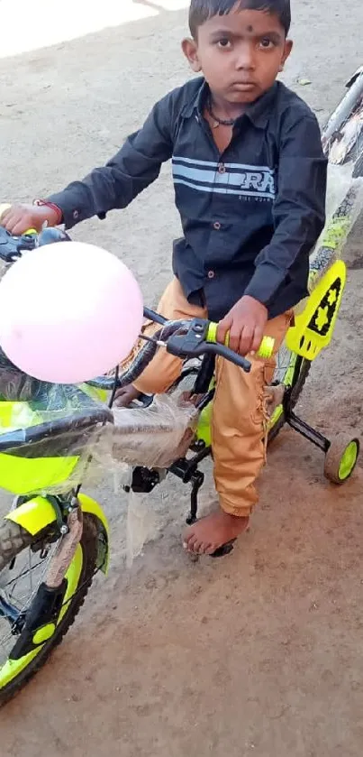 Child riding bright green bicycle with a pink balloon.