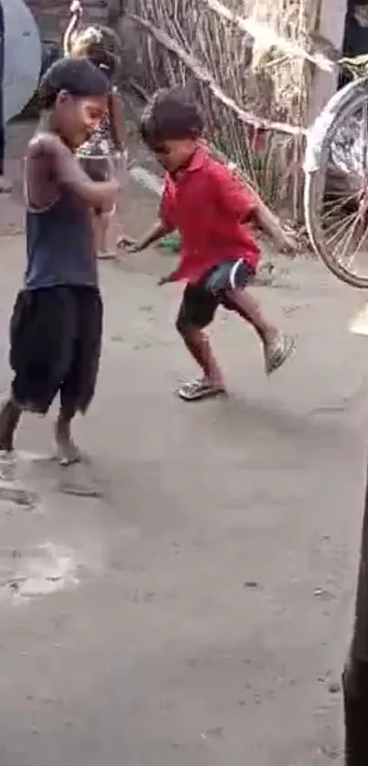 Two children playing outdoors in a village setting.