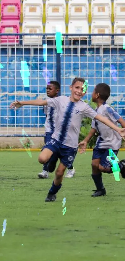 Kids playing soccer on green field with colorful stadium backdrop.