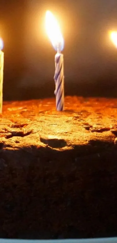 Chocolate cake with three glowing candles.