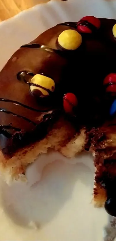 Chocolate donut with colorful candy on a white plate.