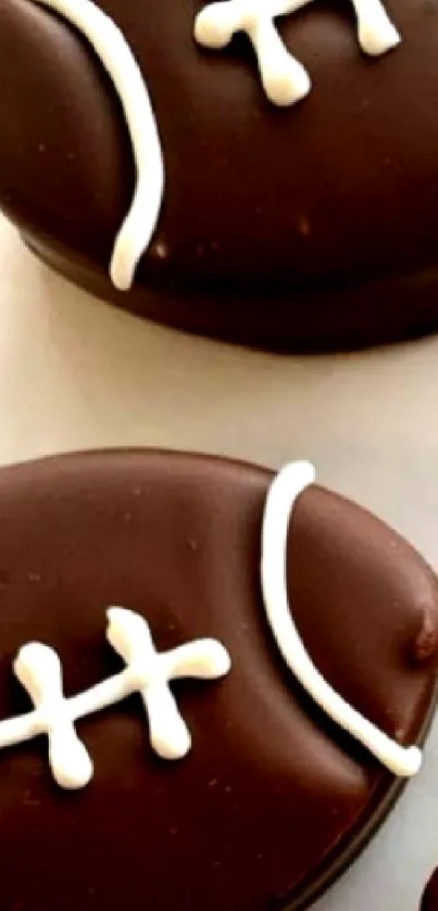 Chocolate football shaped cookies with white icing lines.